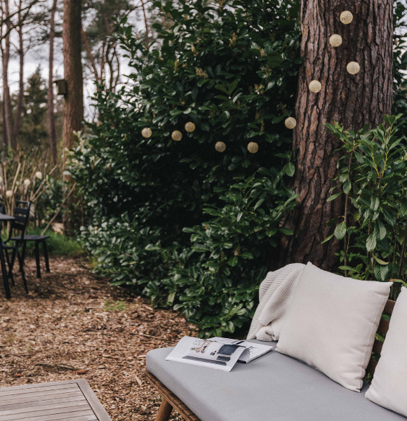 Sfeervol bankje in de tuin van Tiny House Onyx, ideaal om te ontspannen