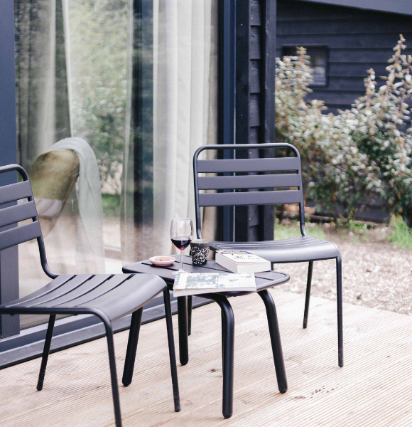 Genieten van een boek en een glas wijn op het terras van Tiny House Onyx