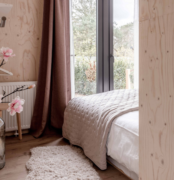 Romantische knusse slaapkamer met luxe bed in Tiny House Onyx op de Veluwe